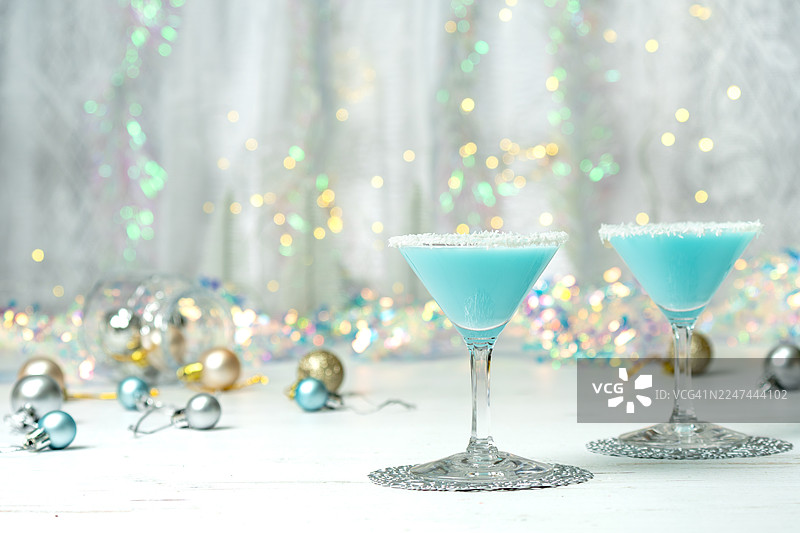 蓝色的杰克霜冻鸡尾酒，背景是虚焦的灯光和圣诞装饰图片素材