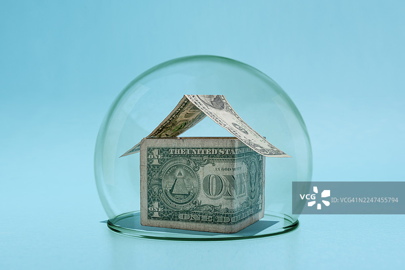 玻璃罩下的美元组成的房屋形状图片素材