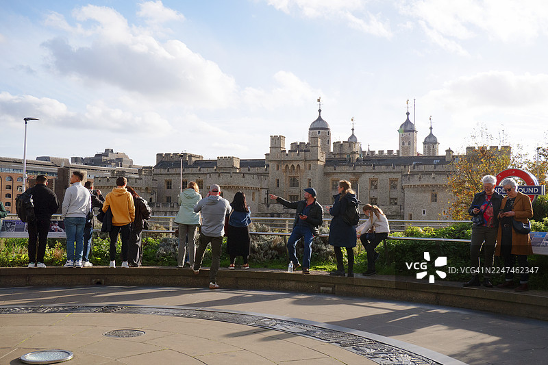 广角镜头，游客在塔丘（Tower Hill）眺望伦敦塔（The Tower of London）并拍照留念图片素材