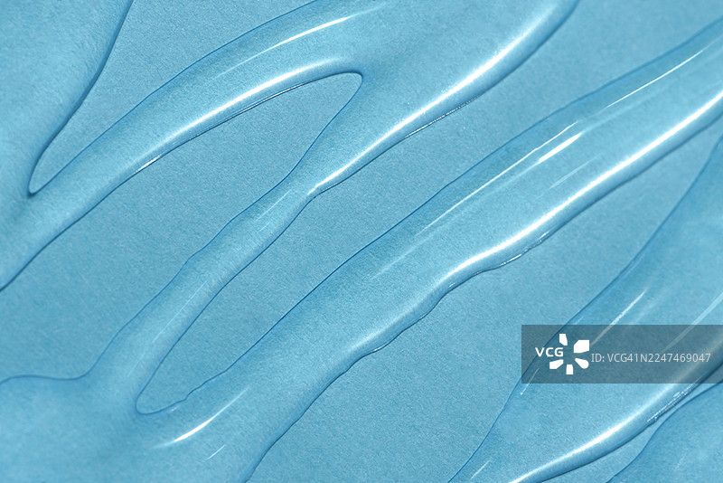 抽象纹理。液体凝胶化妆品。蓝色背景。图片素材