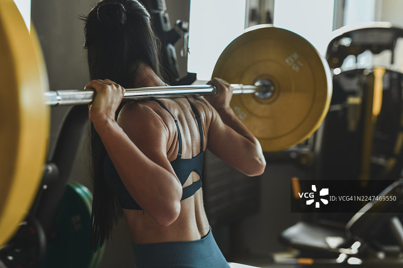 一位强壮的女性在现代健身房进行健身训练和举重图片素材