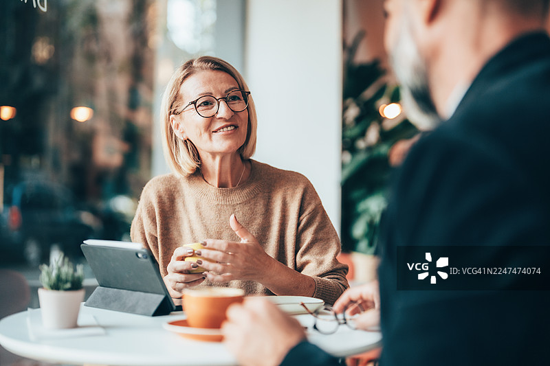 年长专业人士在咖啡馆举行非正式商务会议图片素材