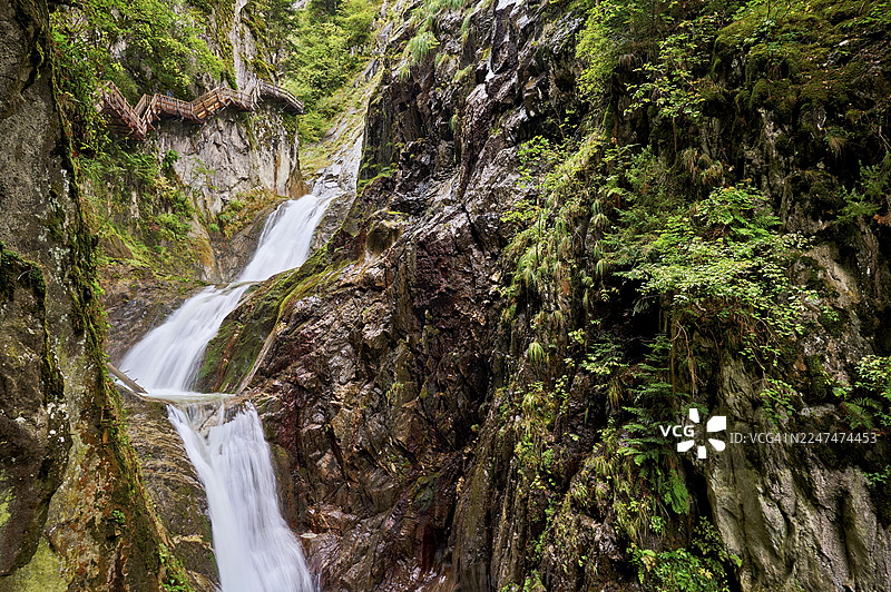 瑞士瓦莱州莱瓦莱特市杜尔南峡谷的木制步道，旁边是瀑布图片素材