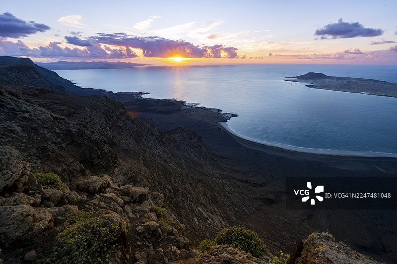 从陡峭悬崖望向大海和海岸，伴有太阳星芒，日落时分的米拉多尔德尔波里托观景点，兰萨罗特，加那利群岛，西班牙图片素材