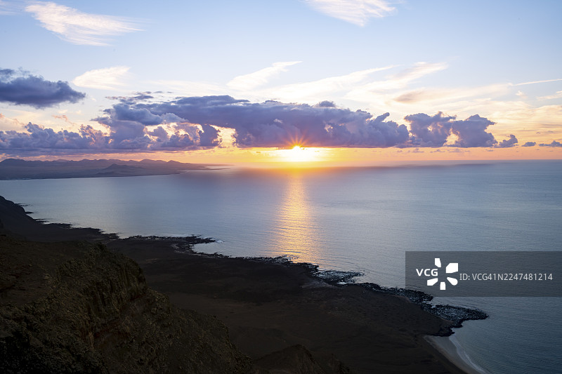 从陡峭悬崖望向大海和海岸，看到太阳星，日落时分的米拉多尔德尔波里托观景点，兰萨罗特，加那利群岛，西班牙图片素材