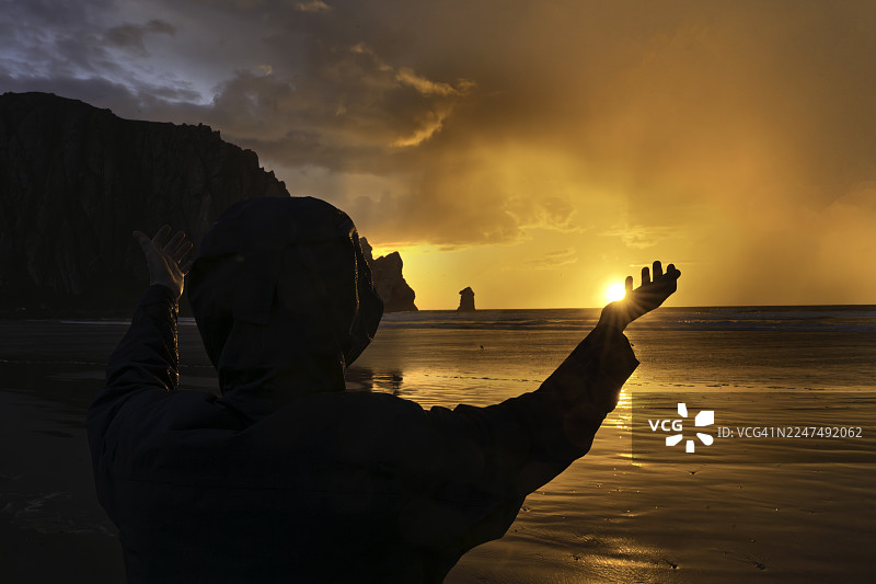 女子在莫罗湾海滩迎接日落，加利福尼亚州圣路易斯-奥比斯波县莫罗湾图片素材