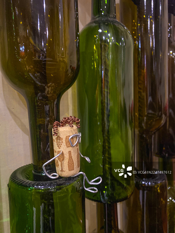 舒适室内环境中，创意软木人偶坐在绿色玻璃瓶上图片素材