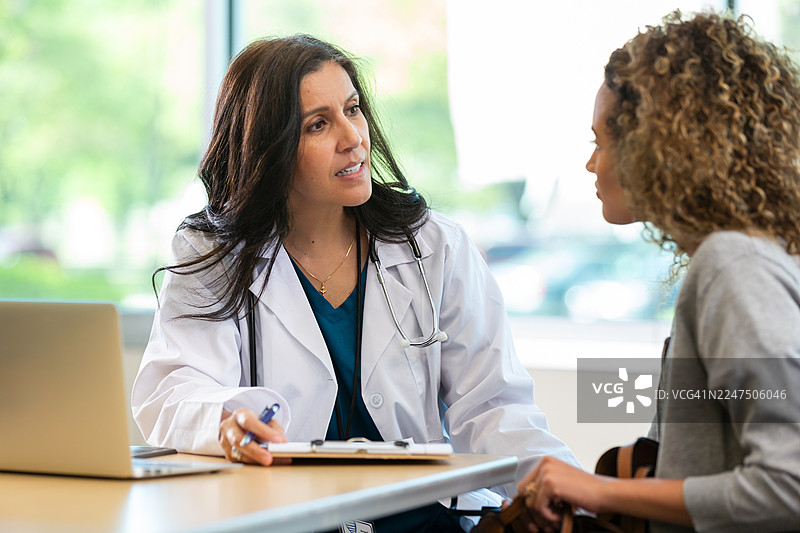 医生在咨询中专注倾听病人，强调医患沟通和健康护理。图片素材