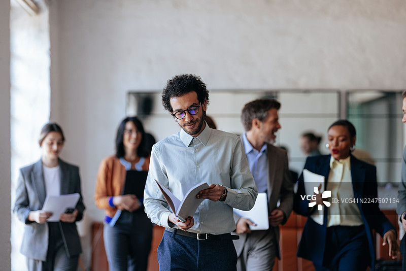 专业的团队在办公室：多元化的团队协作并审阅文件图片素材