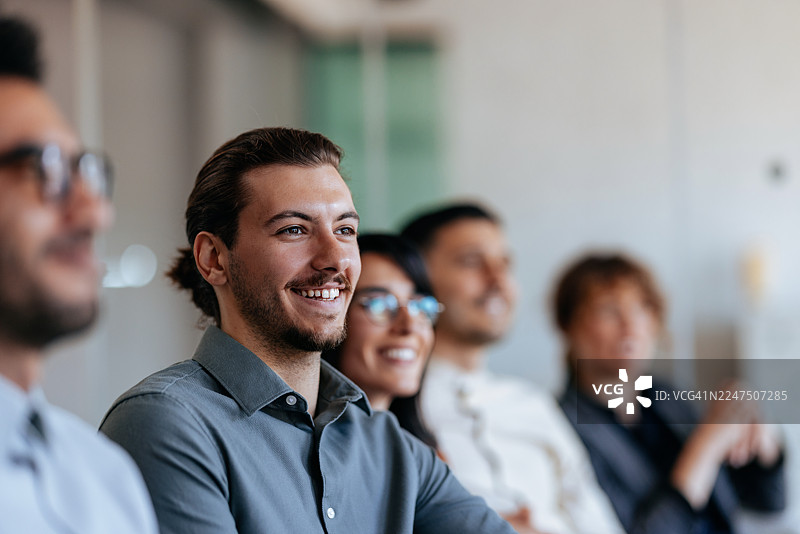 微笑的专业团队正在开会，体现了协作和积极的办公室氛围图片素材