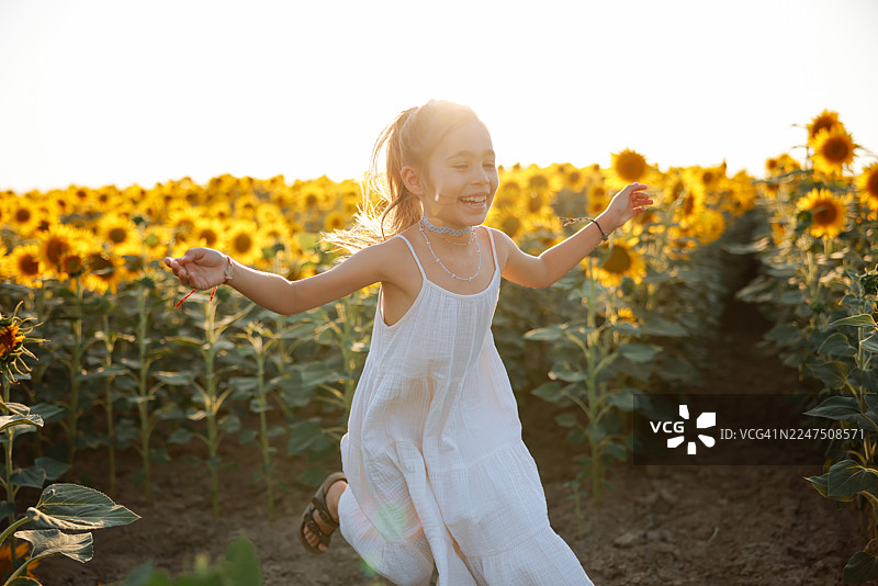 阳光明媚的夏日，孩童在向日葵田中玩耍图片素材