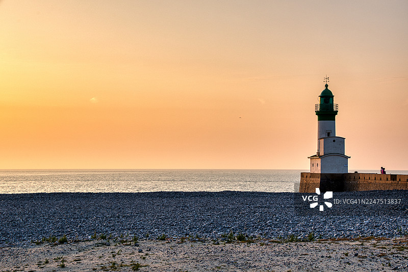 法国海边岩石沙滩上的灯塔，日落时分图片素材