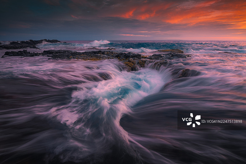 夏威夷科纳海滨旅馆，科纳，美国，美国，戏剧性的海边日落，漩涡状的海水和岩石海岸线图片素材