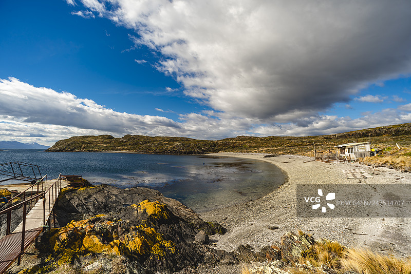 阿根廷巴塔哥尼亚比格尔海峡酒店附近，海湾风景如画，宁静祥和，岸边坐落着一间小木屋，天空戏剧般地变幻着色彩。图片素材
