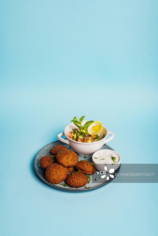 蓝底背景上美味的沙拉三明治、沙拉和蘸酱的俯视视角，非常适合地中海餐图片素材