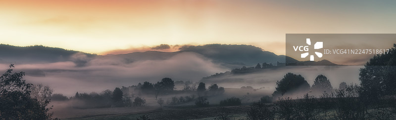 德国埃门丁根，埃门丁根高堡，日落时分，雾气弥漫的山景全景，树木和山丘笼罩在薄雾中图片素材