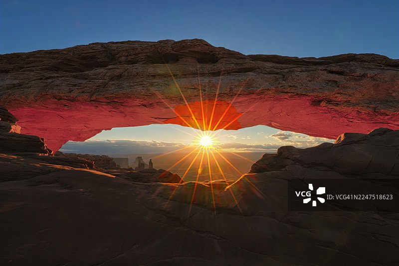 美国犹他州峡谷地国家公园梅萨拱门下的壮丽日落，照亮下方景观图片素材