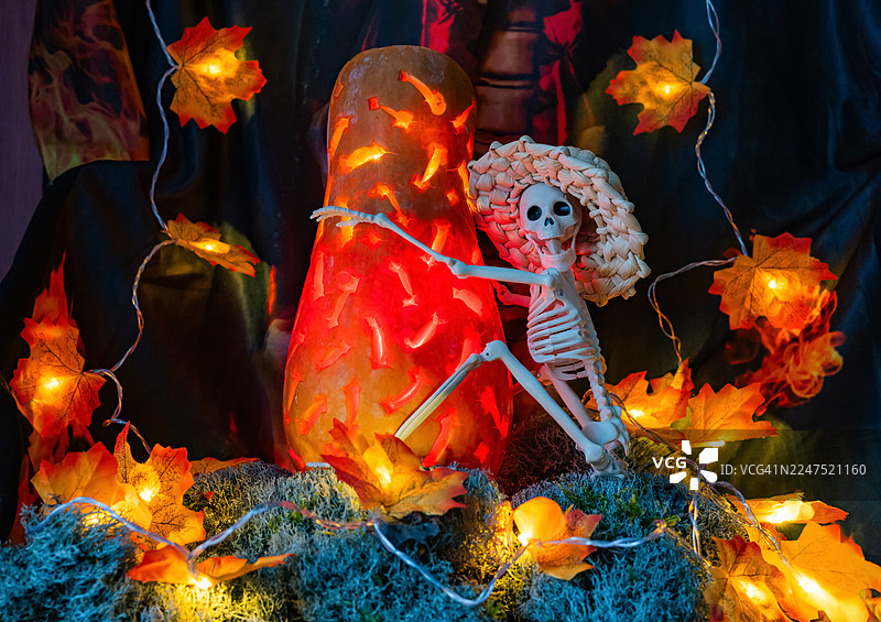 带有骷髅、发光南瓜和秋叶灯的诡异万圣节装饰图片素材