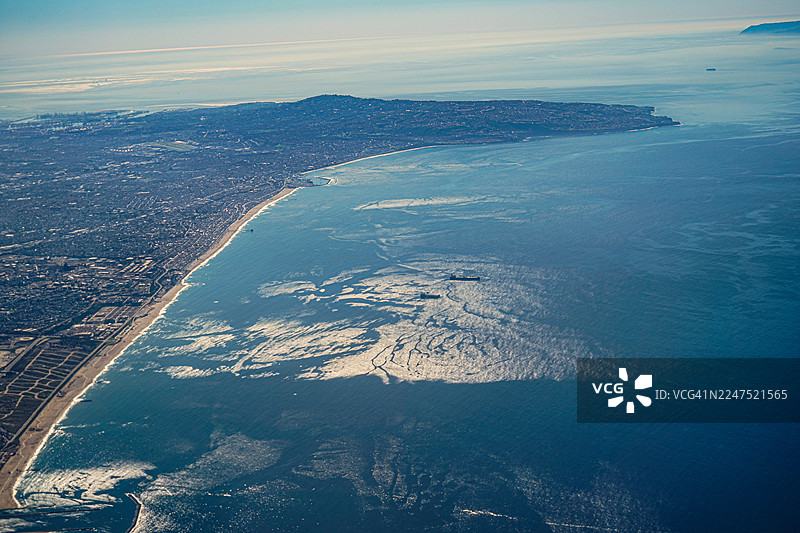 城市、海滩和海洋的海岸线鸟瞰图，天空晴朗图片素材