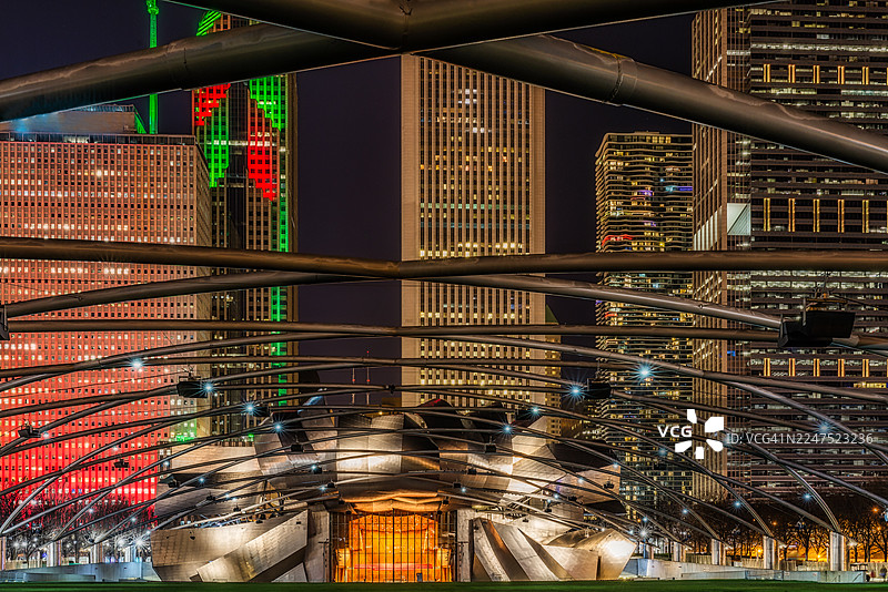 夜幕下的普利兹克露天音乐厅和BP人行桥在芝加哥现代摩天大楼的映衬下，低角度仰视视角，美国芝加哥，E Randolph St图片素材