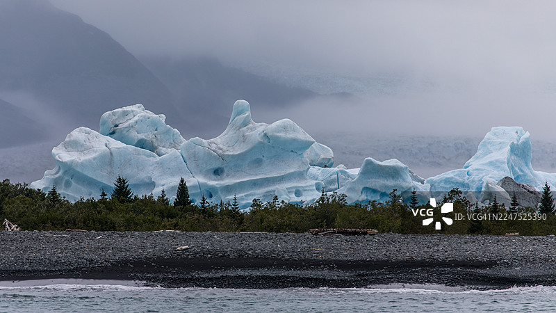 冰封湖泊、冰层和岩石海岸在雾气笼罩的天空下的风景，美国，美国，基奈半岛自治市图片素材