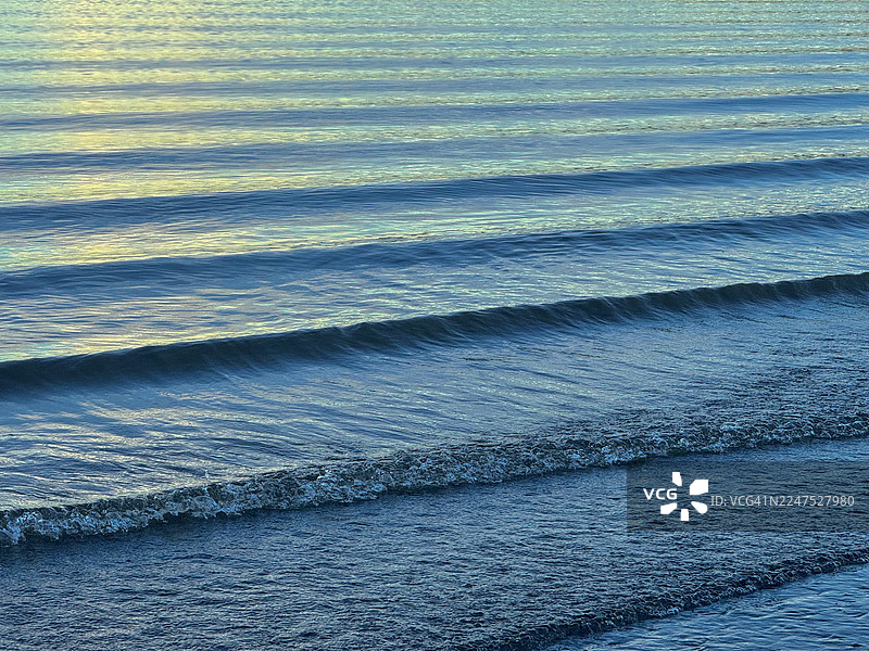 美国华盛顿州伊萨夸市提贝茨溪平静海水的全画幅镜头，带有柔和的波浪和倒影图片素材