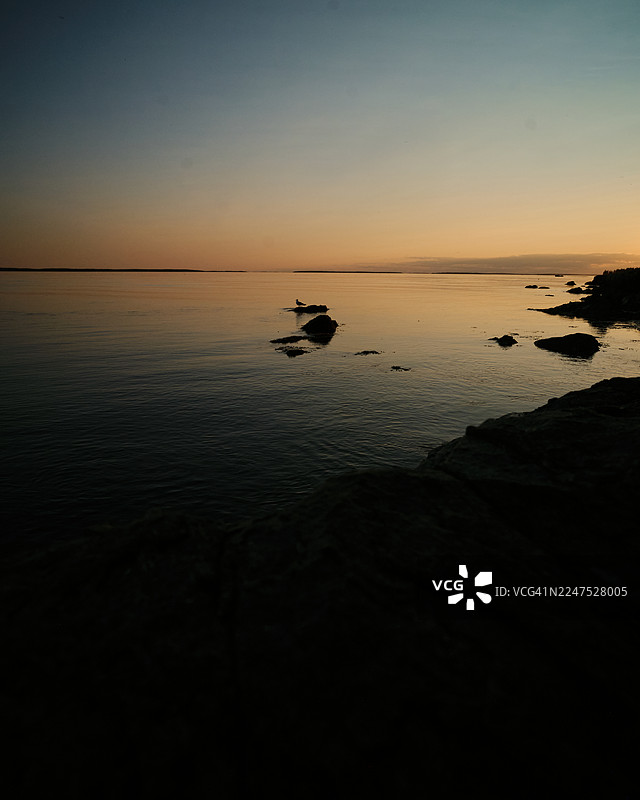 宁静的日落，平静的海水，剪影的岩石，美国巴斯港，巴斯港灯塔图片素材