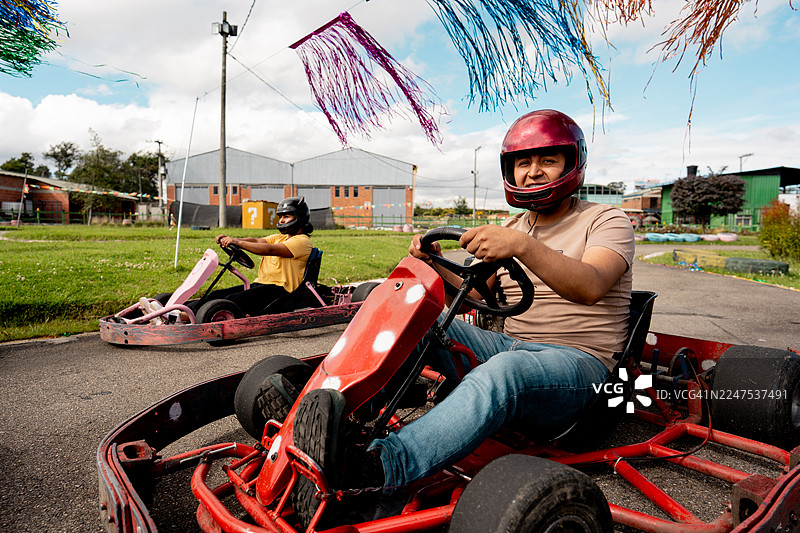 年轻男子在户外赛道上享受卡丁车竞速的肖像图片素材