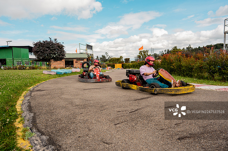 朋友们在户外赛道享受卡丁车比赛图片素材