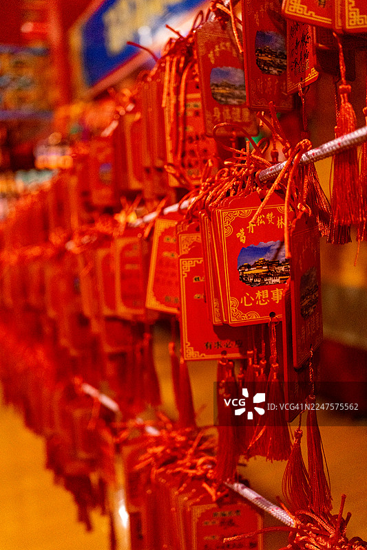 寺庙里悬挂着一排排充满活力的红色中国幸运符，设计精美，带有流苏，象征着对好运、祝福和文化传统的祈愿图片素材