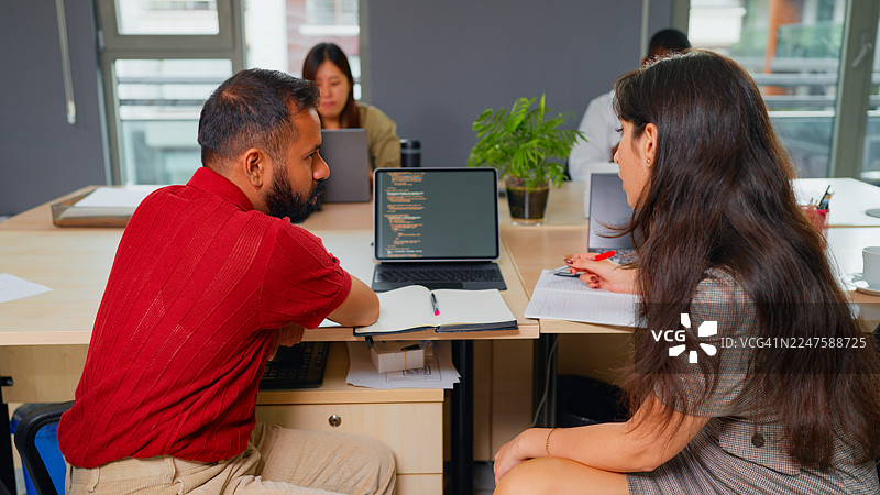 两位多元化的跨种族程序员在办公室协作图片素材