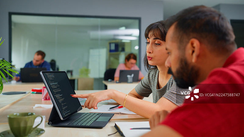 两位多元种族的程序员在办公室合作图片素材