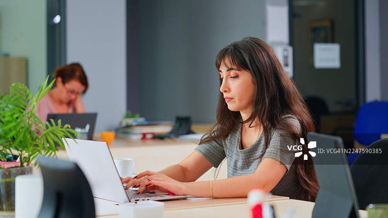 女商人正在办公室用笔记本电脑工作图片素材