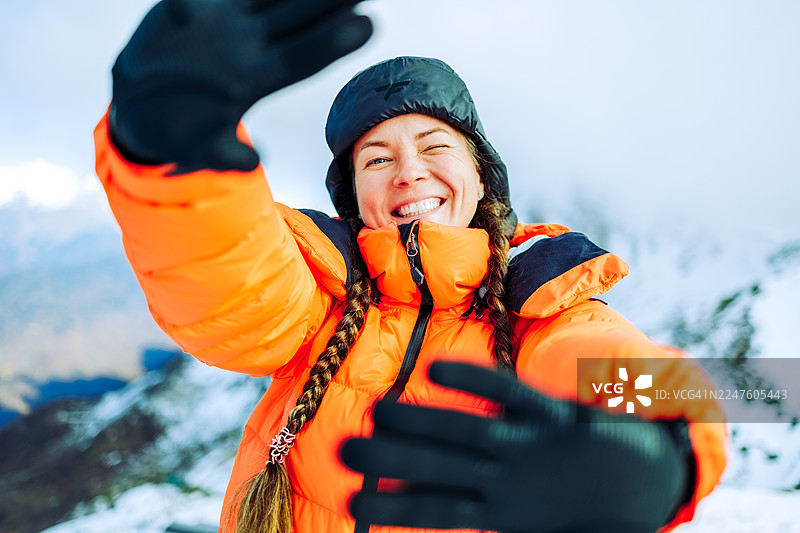 快乐的女人在冬日雪山中享受时光图片素材