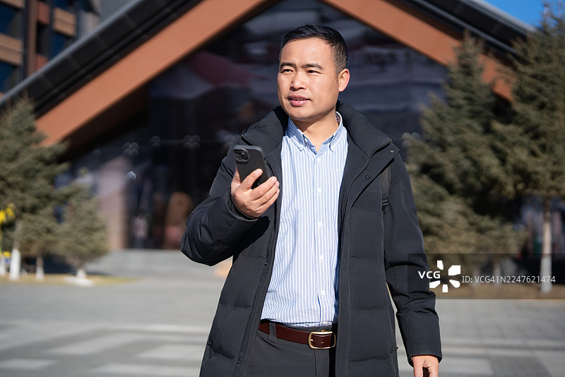 一位中年亚洲男子正在联系客户图片素材