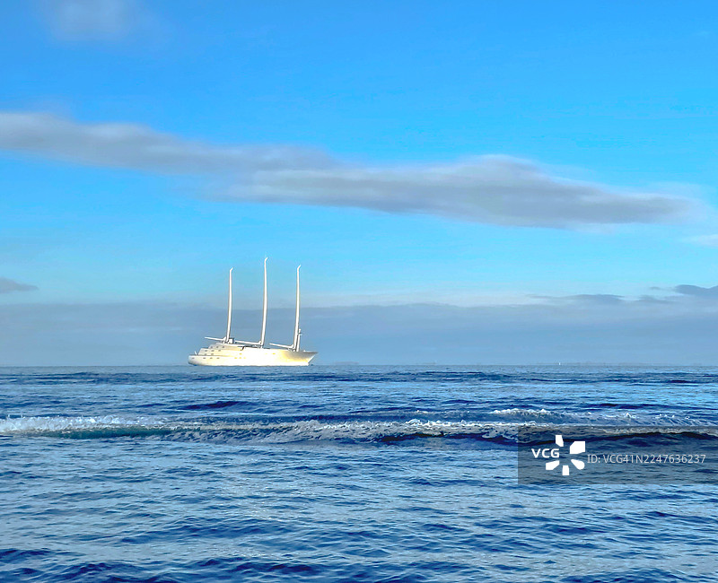 宁静蓝色地平线上的现代帆船图片素材