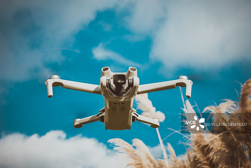 四轴飞行器无人机在云层密布的天空中飞行图片素材