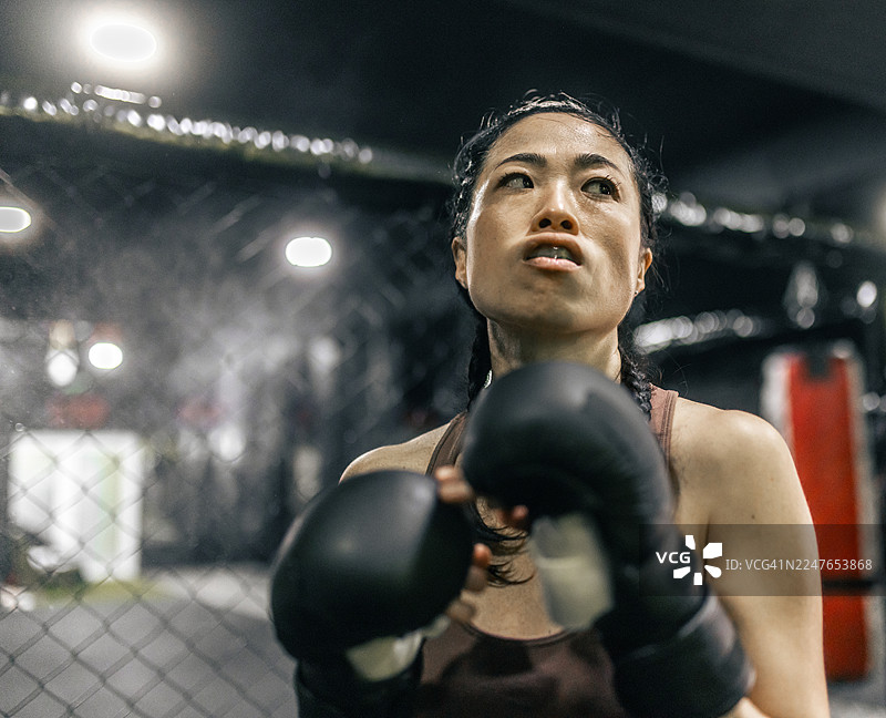 一位自信的亚洲女性MMA拳击手走上擂台图片素材