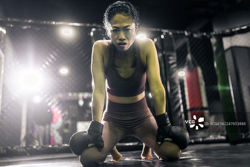 一位自信的亚洲女子MMA拳击手走上擂台图片素材