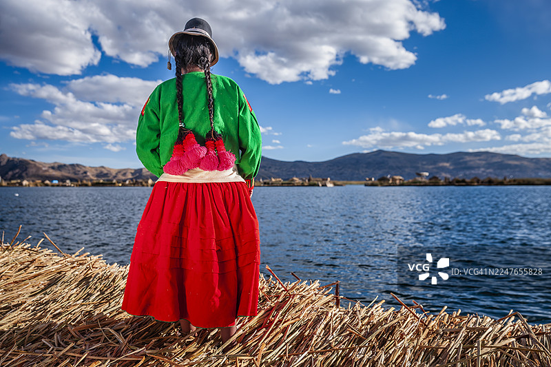 一位秘鲁妇女在的的喀喀湖乌鲁斯浮岛上眺望风景图片素材