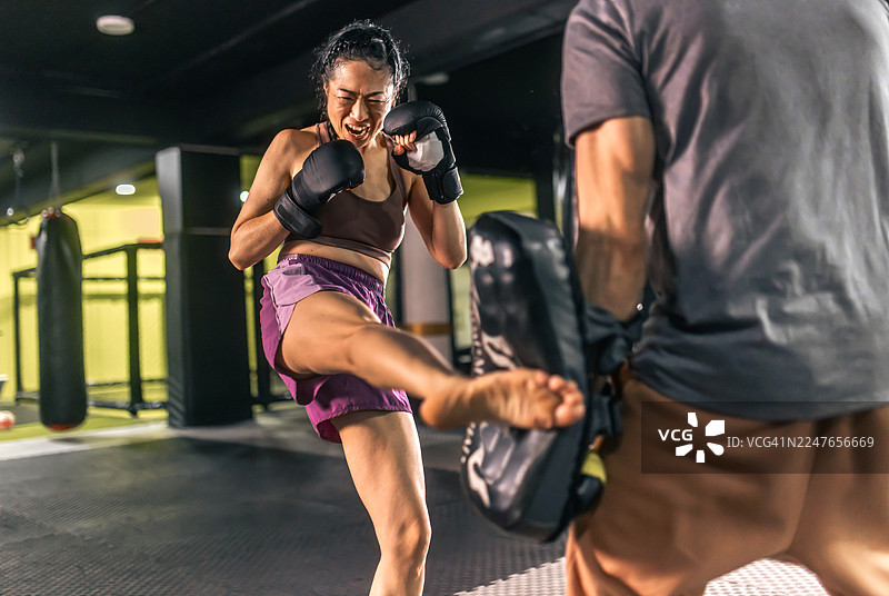 女性在激烈搏击训练中练习踢拳图片素材