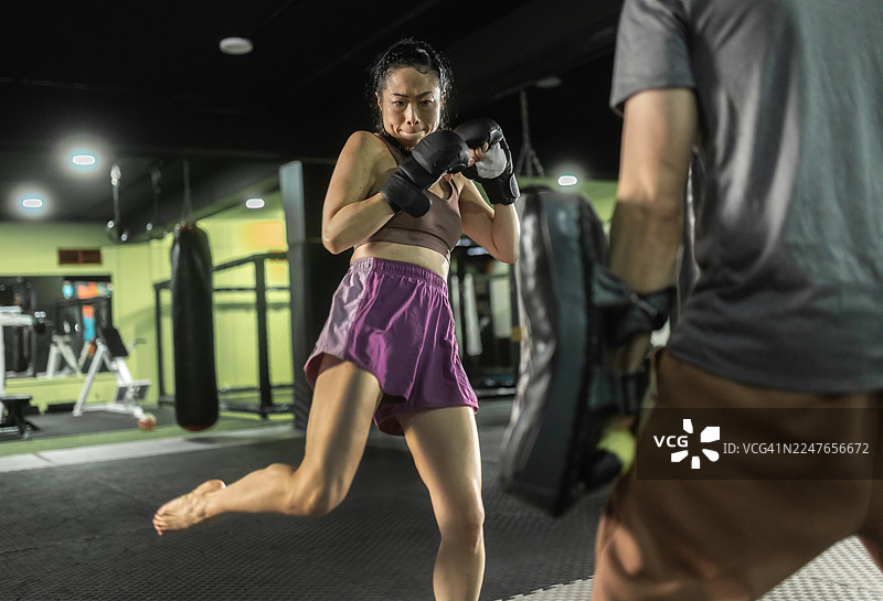 女子在激烈的搏击对练中练习踢拳图片素材