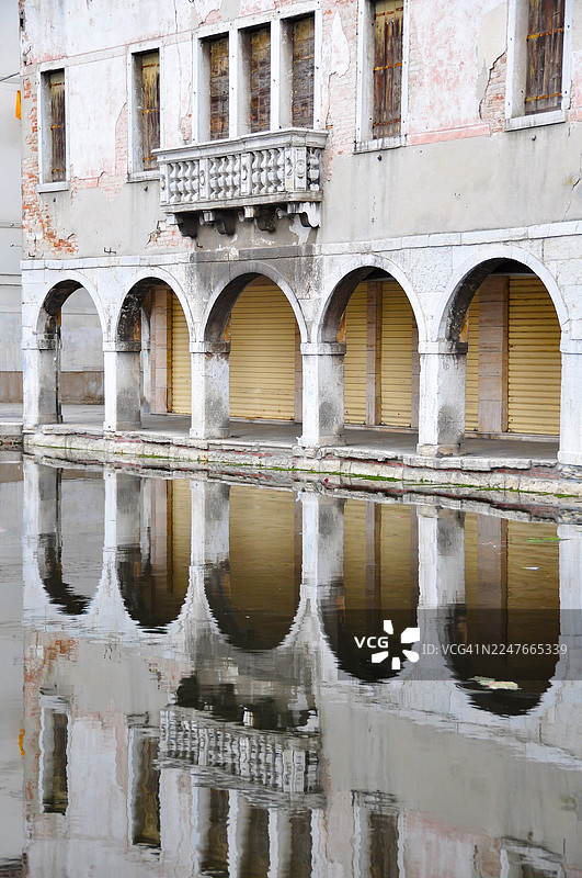 意大利基奥贾威尼斯附近，维拉运河两岸建筑物的完美对称倒影。图片素材
