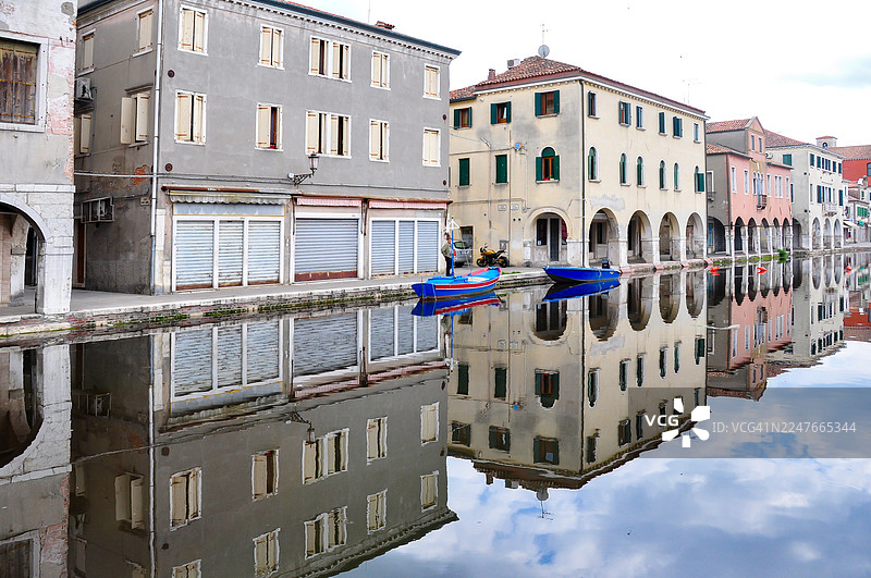威尼斯附近基奥贾大运河沿岸建筑的完美对称倒影。图片素材