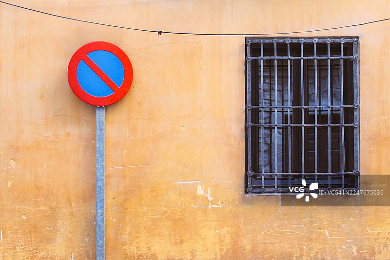 橙色墙壁和窗户前的禁止停车标志图片素材