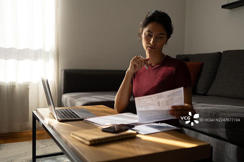 女性在家管理家庭预算，计算开支图片素材