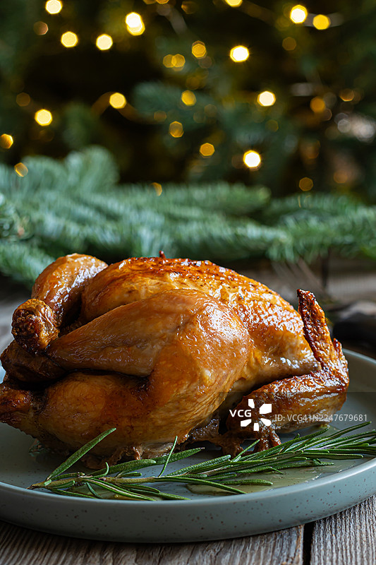 节日圣诞美食，新鲜出炉的烤鸡，火鸡放在木质背景上。节日美食。图片素材