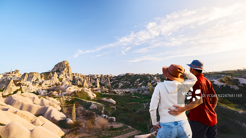 一对情侣正在欣赏仙人烟囱和一座古老城堡图片素材