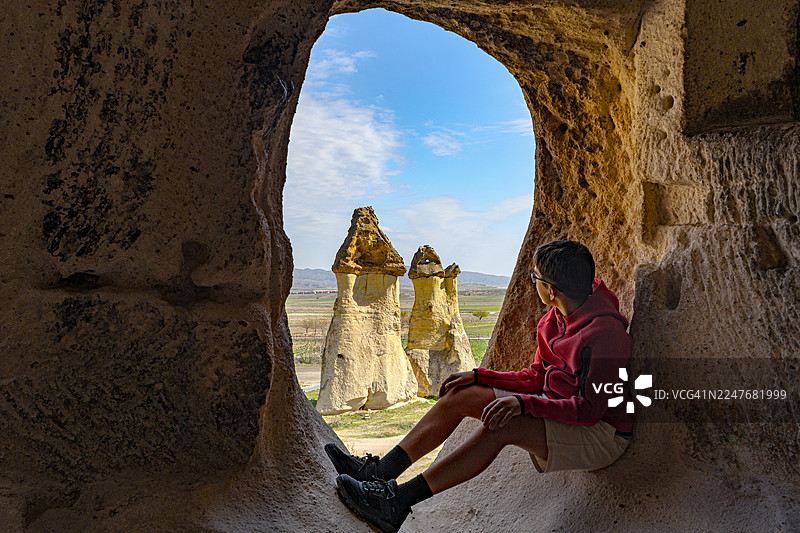 男孩从洞穴内观察仙人烟囱图片素材