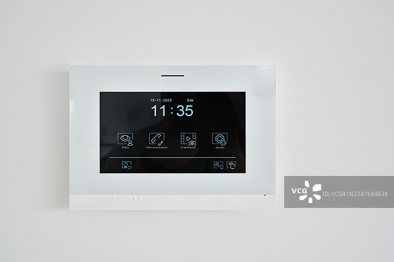 现代智能家居控制面板，安装在白色墙壁上，特写镜头图片素材
